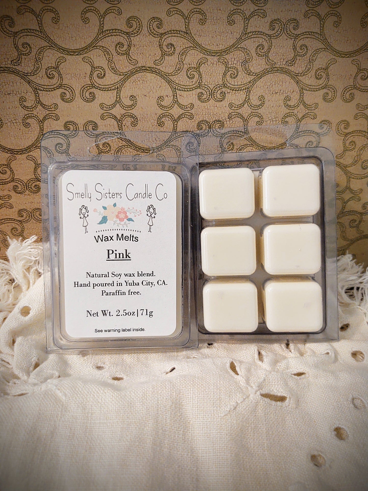 A clear plastic clamshell packaging containing six dye free wax melts with natural soy wax and beeswax, paraffin-free, hand-poured. Perfume scented.