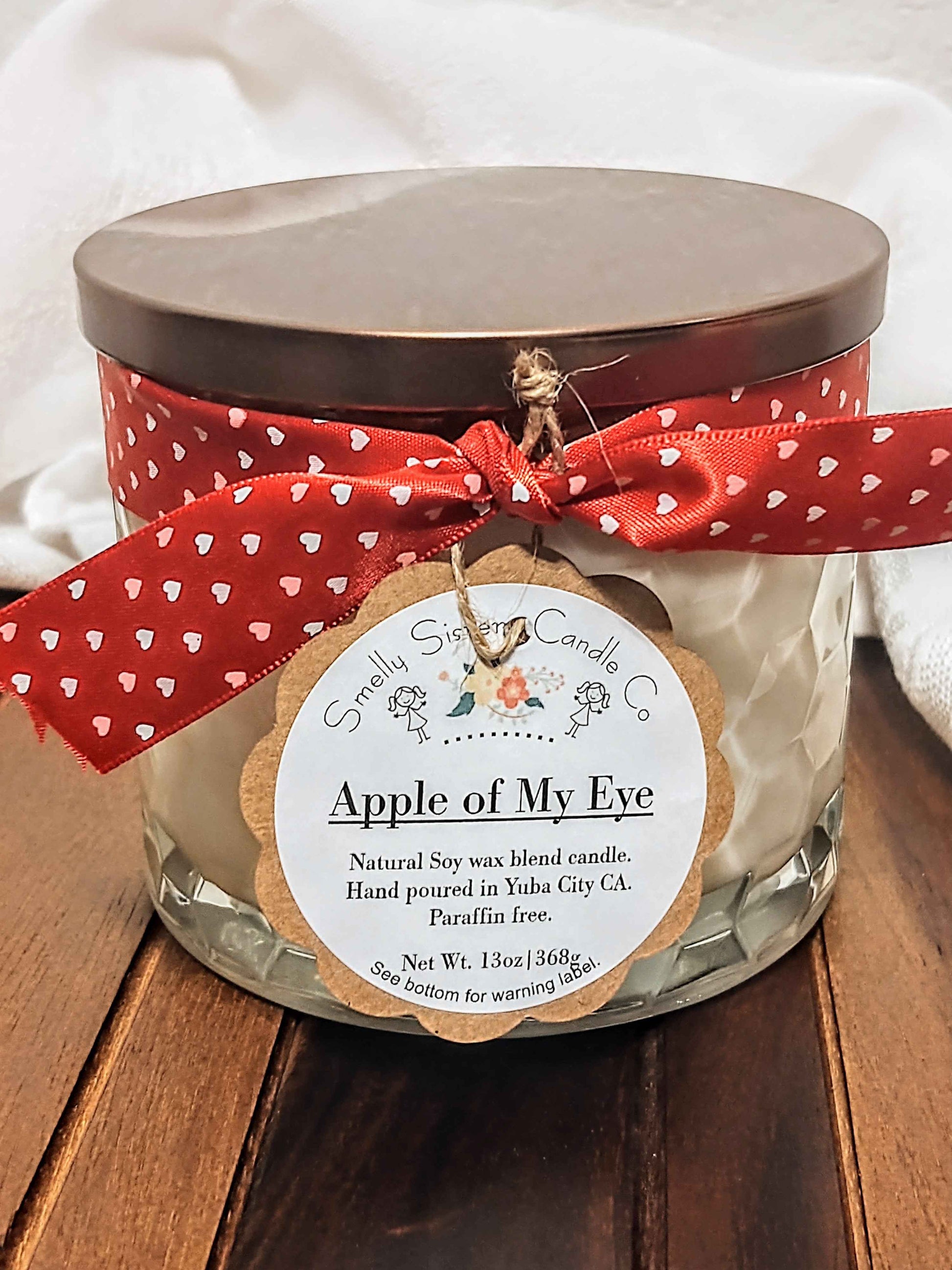 A hand-poured large 3-wick natural soy and beeswax candle in a luxury glass vessel with a bronze metal lid. Dye free, paraffin free, phthalate free, non-toxic cotton wicks. Fresh, sweet, apple scented.