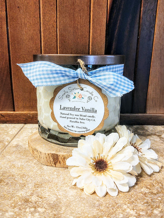 Natural soy wax Lavender and vanilla scented candle in a clear glass jar with a decorative ribbon around it.